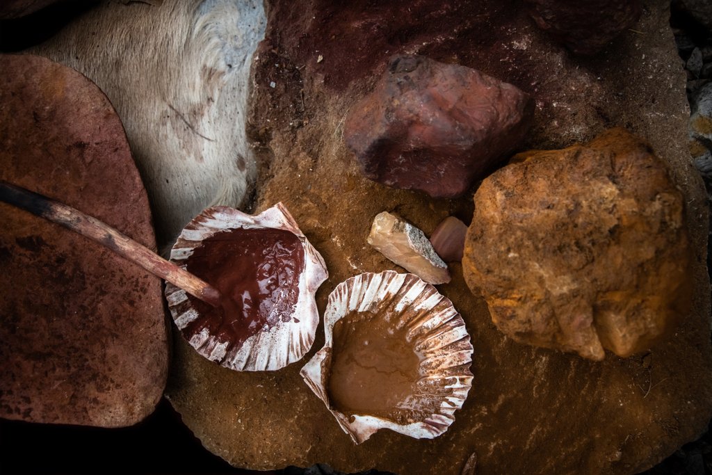 rotbraune und gelbliche Gesteinsklumpen, angerührte Farbe in Muschelschalen 