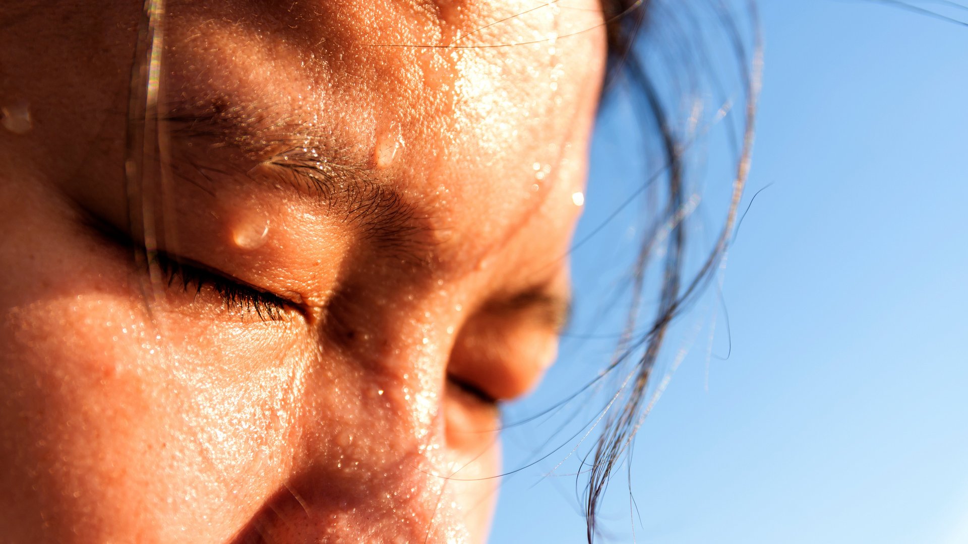 Nahaufnahme des verschwitzten Gesichts einer jungen asiatischen Frau